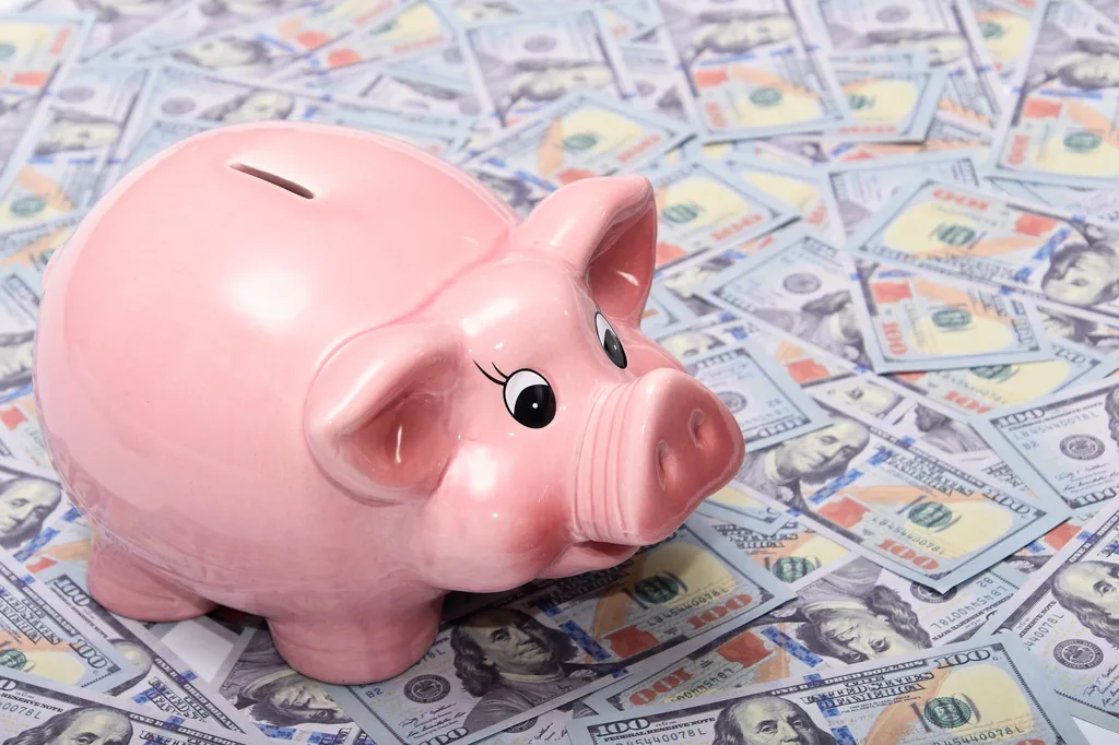 Pink piggy bank on US dollar bills illustrating high-yield savings account interest