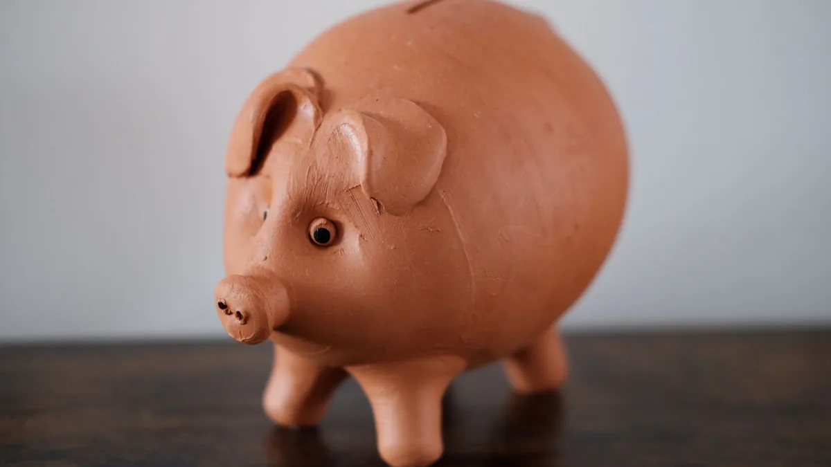 Terracotta piggy bank on a wooden table representing a high-yield savings account