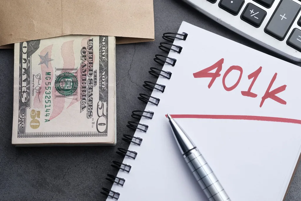 Retirement planning notebook with cash, pen and calculator for Roth IRA and traditional IRA decisions